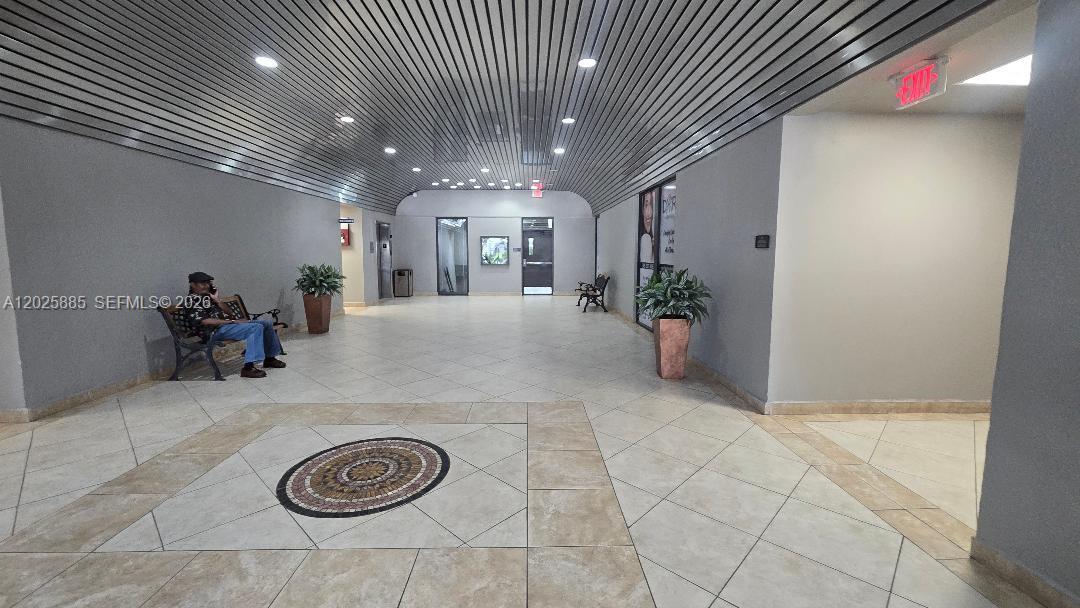 A spacious lobby features a tiled floor with a central mosaic, benches, and metal ceiling — 8370 W Flagler St # 246, Miami FL 33144, MIAMI, FL