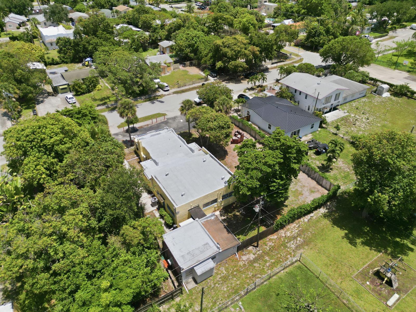 An aerial view shows a yellow building with a flat roof surrounded by trees — 216 SW 2nd Avenue, Delray Beach FL 33444, DELRAY BEACH, FL