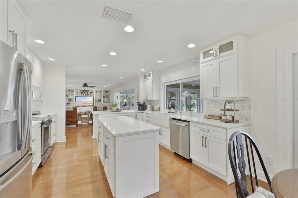A single-story house with a tan exterior, a white garage door, and a green lawn — 412 STONEHAM DRIVE, SUN CITY CENTER, FL