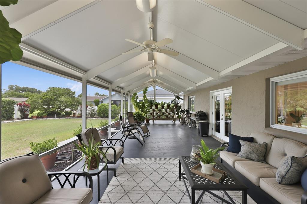 A living room features two leather armchairs, a white sofa, and built-in shelving with a television — 412 STONEHAM DRIVE, SUN CITY CENTER, FL