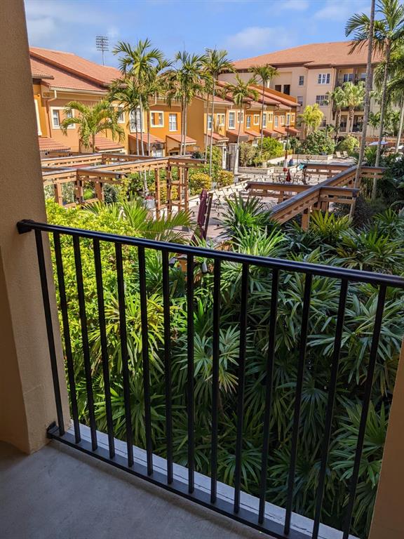 A view from a balcony overlooking a courtyard with palm trees and wooden pergolas — 100 4TH AVENUE S UNIT 224, ST PETERSBURG, FL