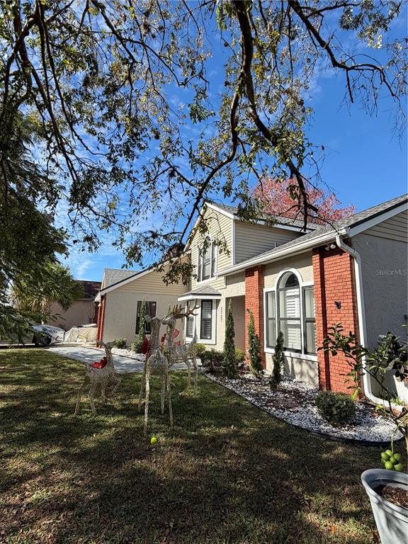 A two-story house with light siding, brick accents, and wire deer decorations on the lawn — 2007 NORFIELD COURT, ORLANDO, FL
