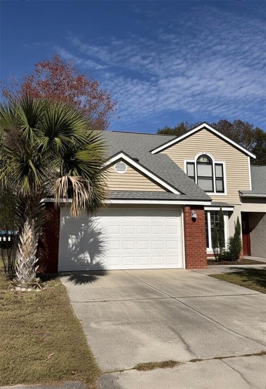A two-story house with a brick and beige siding exterior, a two-car garage, and a palm tree — 2007 NORFIELD COURT, ORLANDO, FL