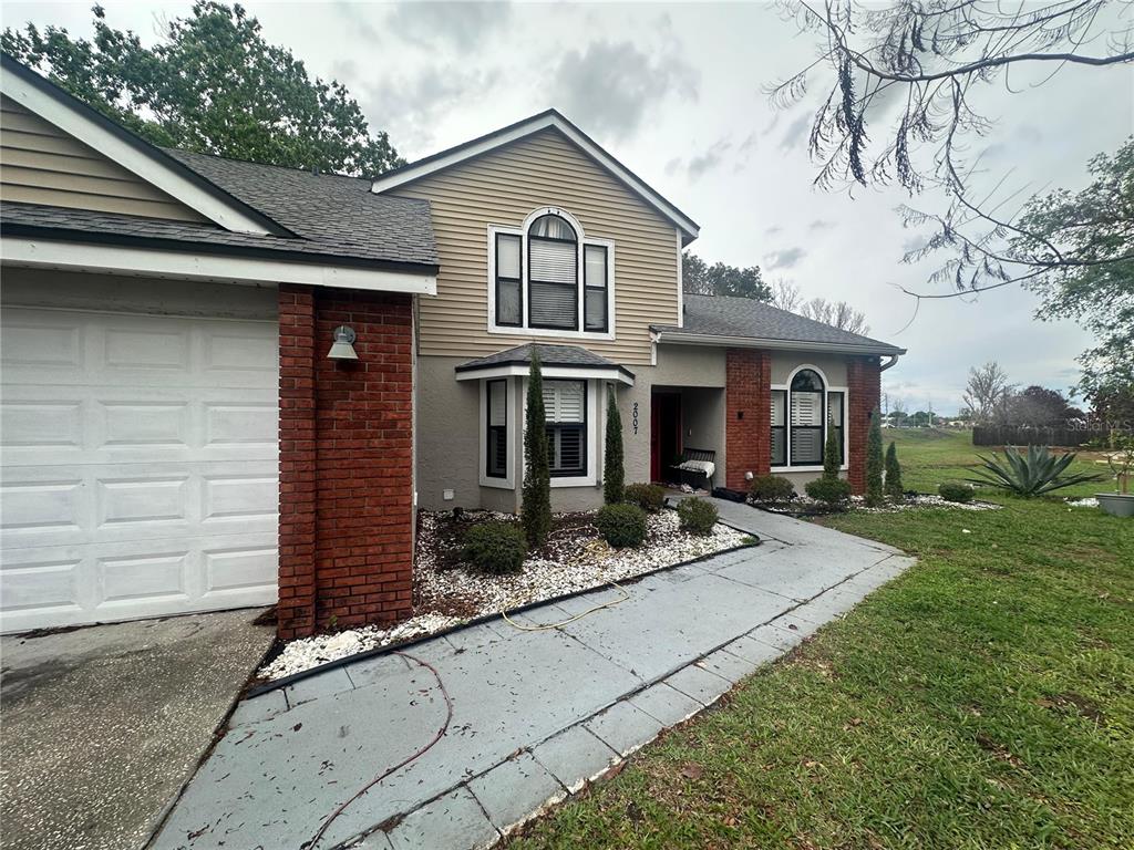 A two-story house with a brick and beige siding exterior, a garage, and a walkway — 2007 NORFIELD COURT, ORLANDO, FL