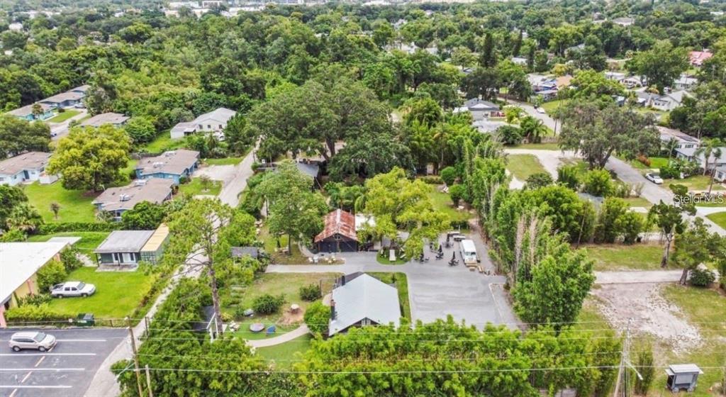 An aerial view of a property featuring several buildings, mature trees, and a paved parking area — 4421 EDGEWATER DRIVE, ORLANDO, FL