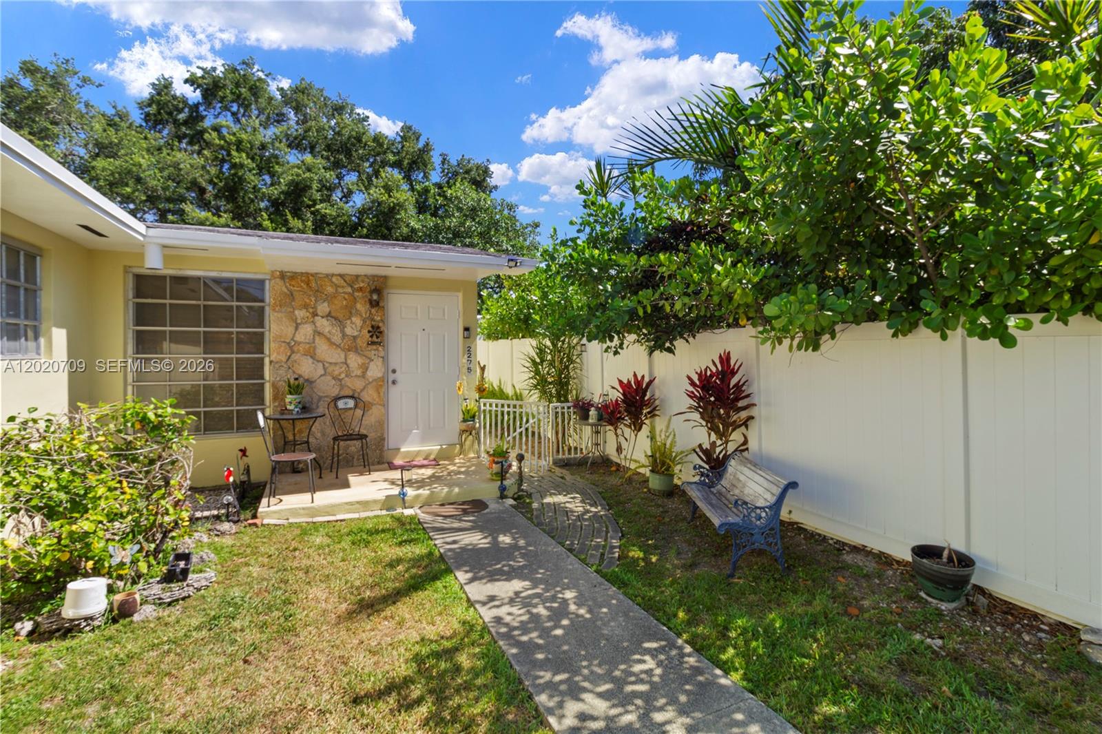 A stone-accented house entrance features a small porch, a walkway, and a white fence — 2275 SW 15th St, Miami FL 33145, MIAMI, FL