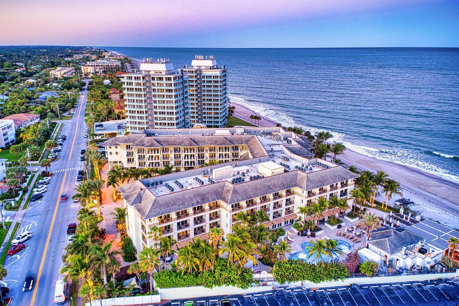 An aerial view shows a beachfront hotel complex with a pool, parking, and nearby ocean — 3500 Ocean Drive # 228, Vero Beach FL 32963, VERO BEACH, FL