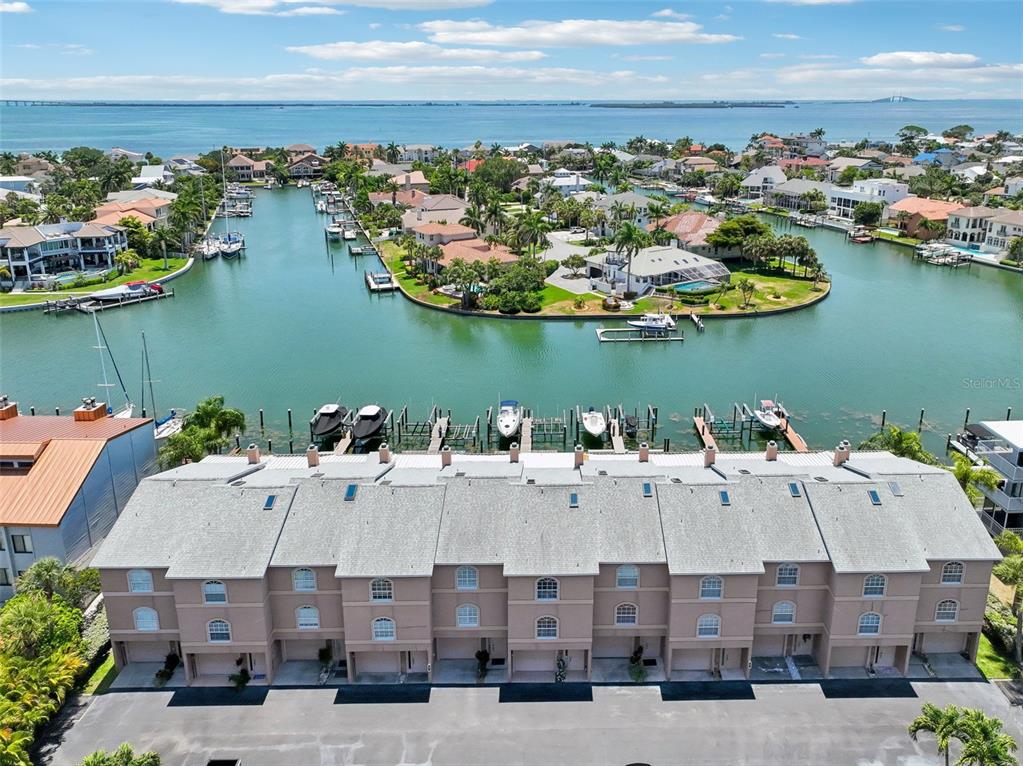 An aerial view shows a multi-unit townhouse complex with private boat slips on a canal — 637 PINELLAS BAYWAY UNIT 105, TIERRA VERDE, FL