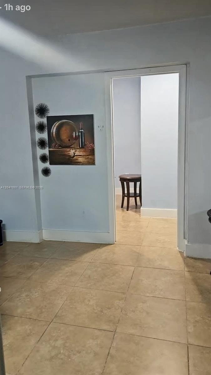 A doorway leads from a tiled room into a small space containing a wooden table — 965 NE 146th St, North Miami FL 33161, NORTH MIAMI, FL
