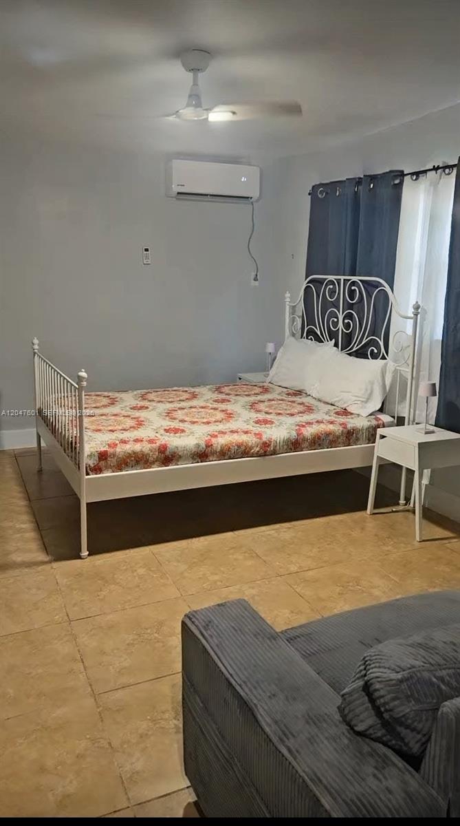 A bedroom features a white metal bed frame, tile flooring, and a wall-mounted air conditioner — 965 NE 146th St, North Miami FL 33161, NORTH MIAMI, FL