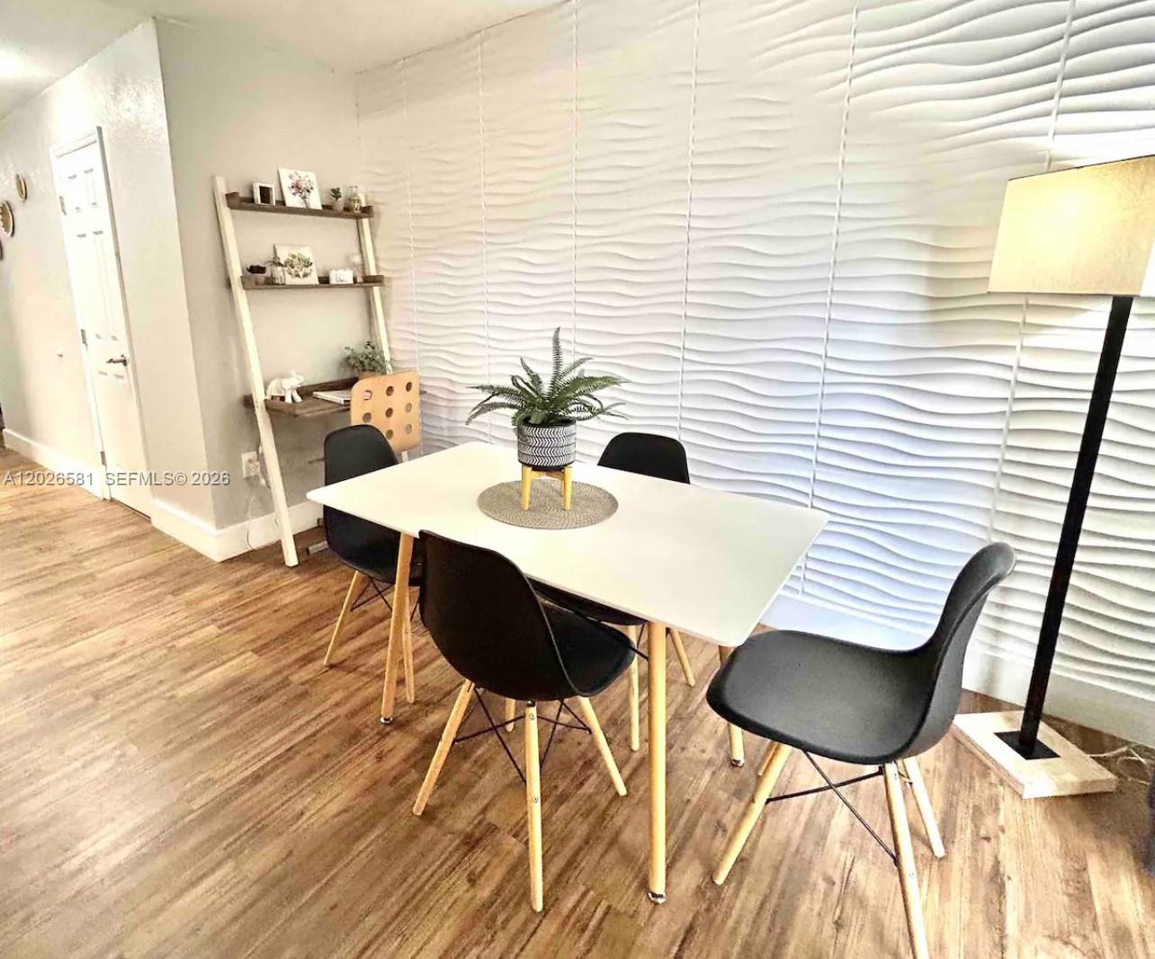 A dining area features a white table, black chairs, and a textured wave-patterned accent wall — 1011 NW 7th Ave # 1011, Miami FL 33136, MIAMI, FL