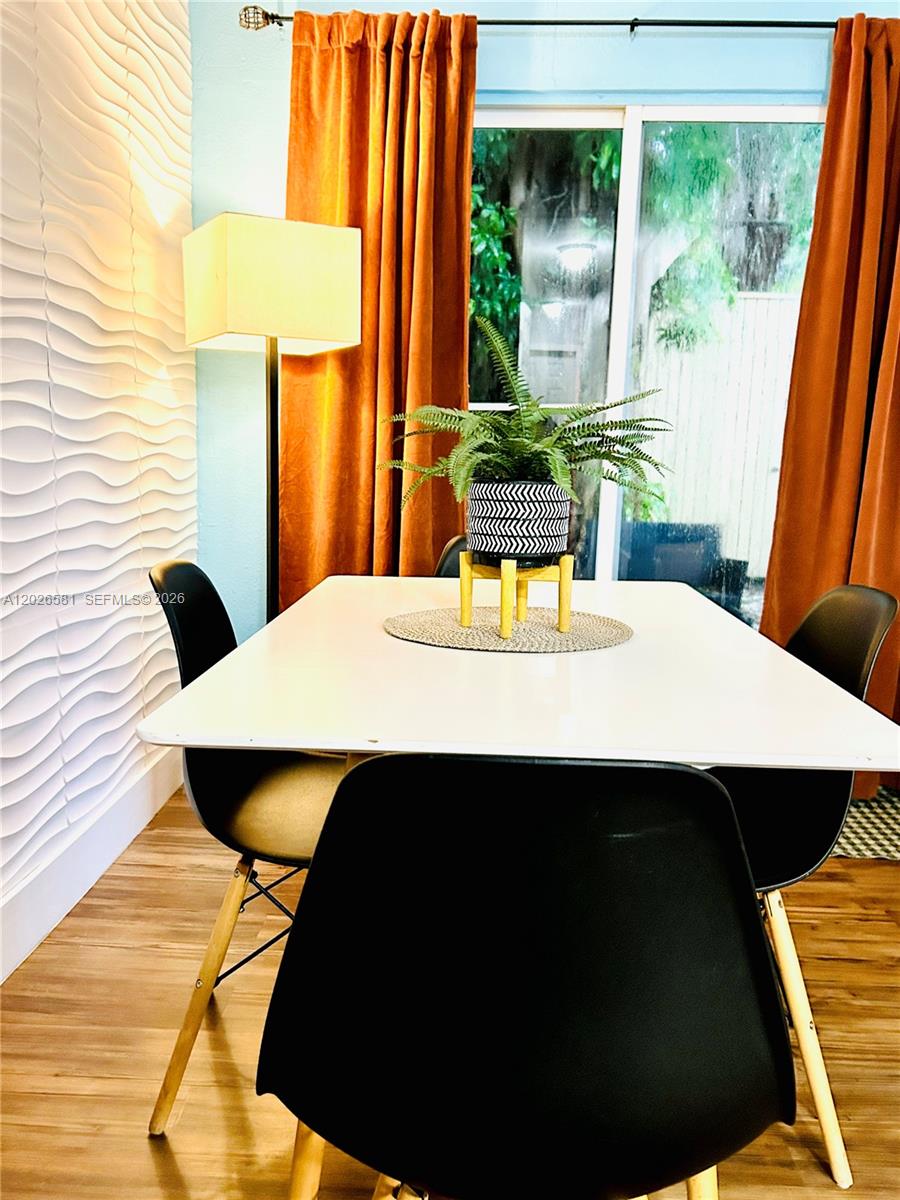 A dining area features a white table, black chairs, a floor lamp, and orange curtains — 1011 NW 7th Ave # 1011, Miami FL 33136, MIAMI, FL