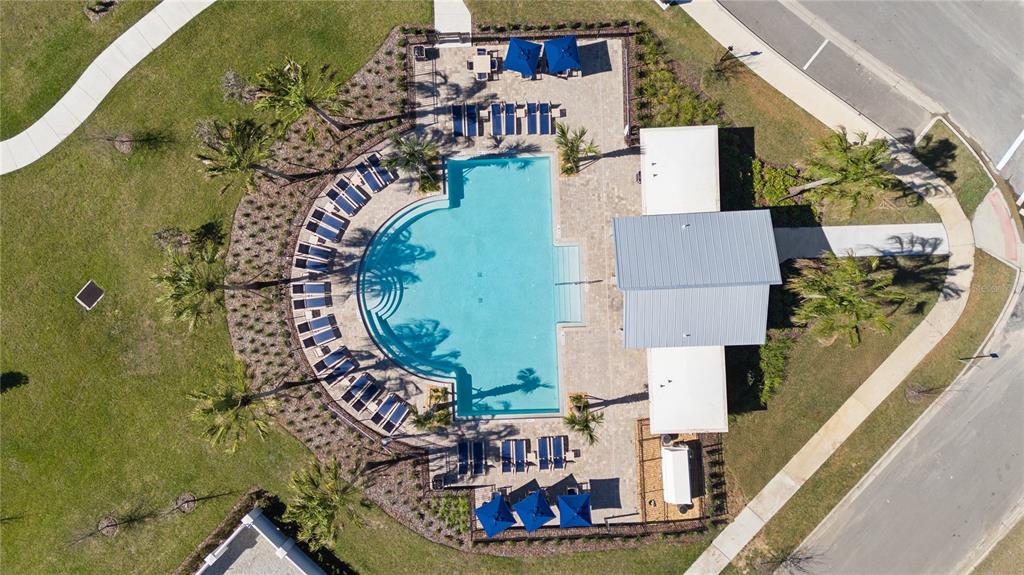 An aerial view shows a swimming pool with lounge chairs and a building with a roof — 4561 GOLDEN KNIGHT TRAIL, KISSIMMEE, FL