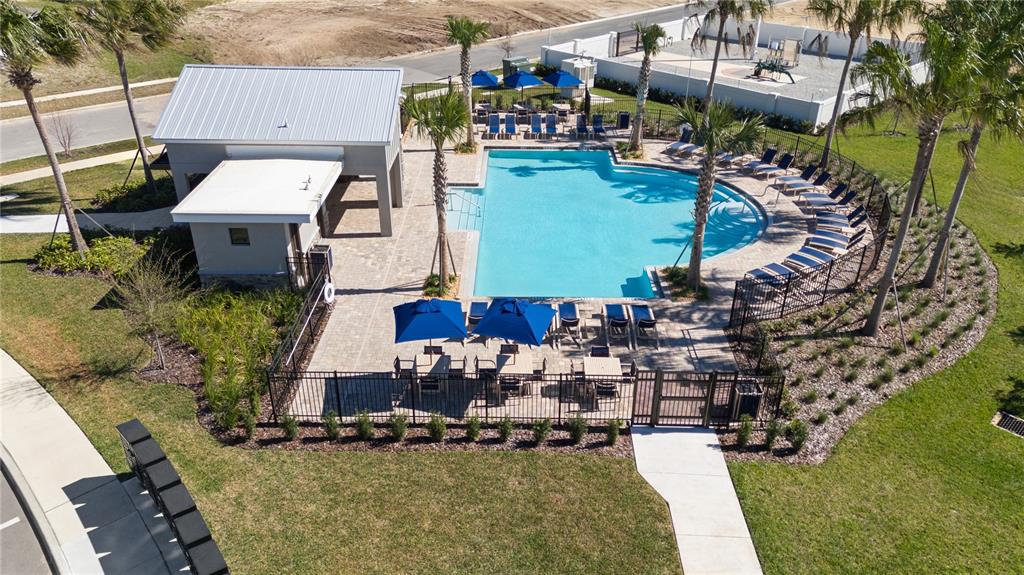An aerial view of a community swimming pool with lounge chairs and a covered pavilion — 4561 GOLDEN KNIGHT TRAIL, KISSIMMEE, FL