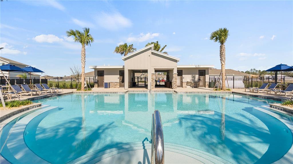 A swimming pool with lounge chairs and a covered pavilion under a blue sky — 4561 GOLDEN KNIGHT TRAIL, KISSIMMEE, FL