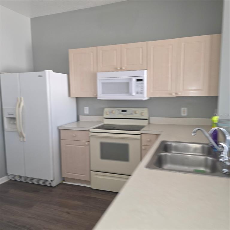 A kitchen features light wood cabinets, white appliances, a double sink, and gray walls — 2403 SILVER PALM DRIVE, KISSIMMEE, FL