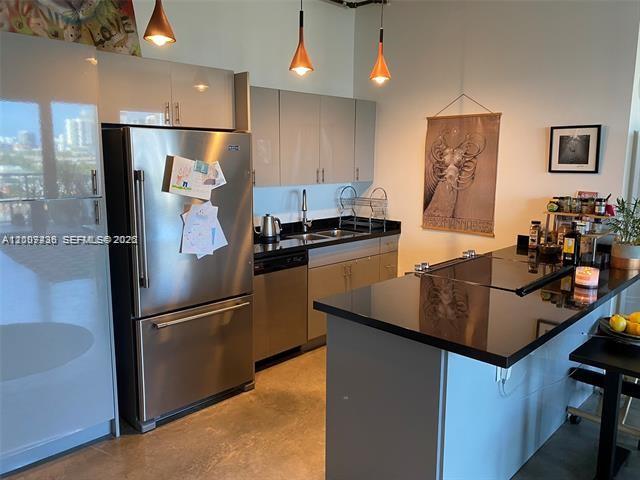 A modern kitchen features stainless steel appliances, gray cabinetry, and a black countertop island — 10 SW South River Dr # 909, Miami FL 33130, MIAMI, FL