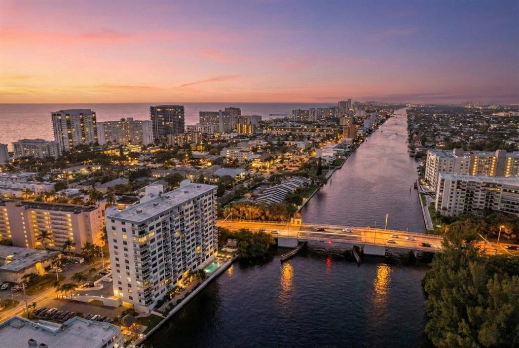 An aerial view of a coastal city at sunset featuring a bridge over a canal — 1401 N Riverside Drive # 307, Pompano Beach FL 33062, POMPANO BEACH, FL
