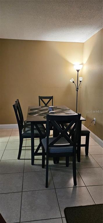A dining area features a dark wood table with four chairs and a floor lamp — 2442 NE 7TH STREET UNIT 3, OCALA, FL