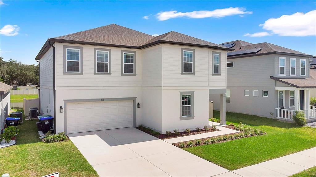 A two-story house with a white exterior, a two-car garage, and a concrete driveway — 9169 WAVERLY WALK DRIVE, ORLANDO, FL