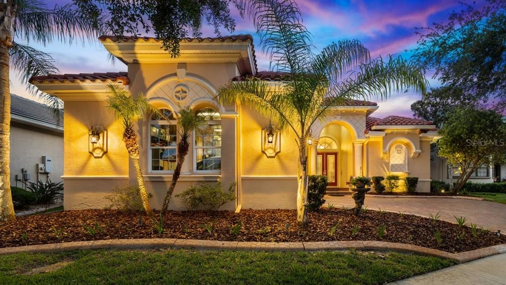 A single-story stucco house with a tile roof, arched windows, and a landscaped front yard — 102 LAGARE STREET, PALM COAST, FL