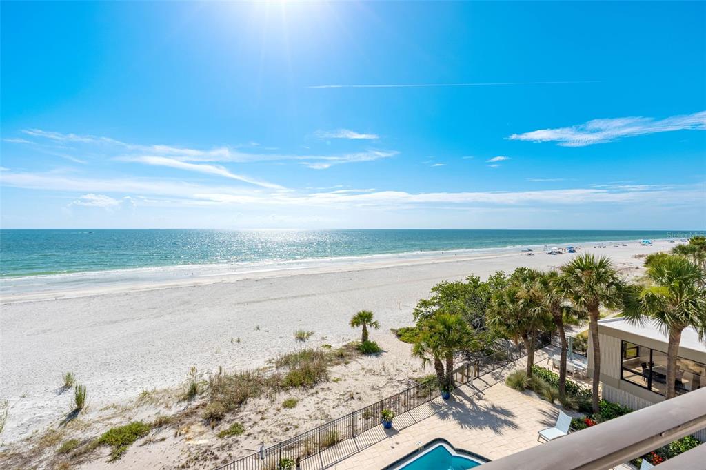 An elevated view of a sandy beach and ocean from a balcony with a pool — 19700 GULF BOULEVARD UNIT 403, INDIAN SHORES, FL
