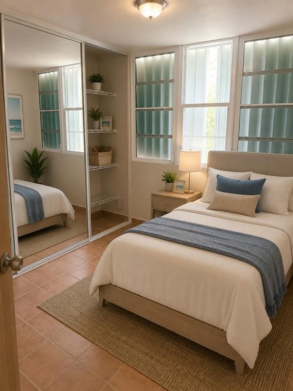 A bedroom features a bed with blue accents, a mirrored closet, and louvered windows — 5015 PUNTA TUNA UNIT 401, MAUNABO, PR