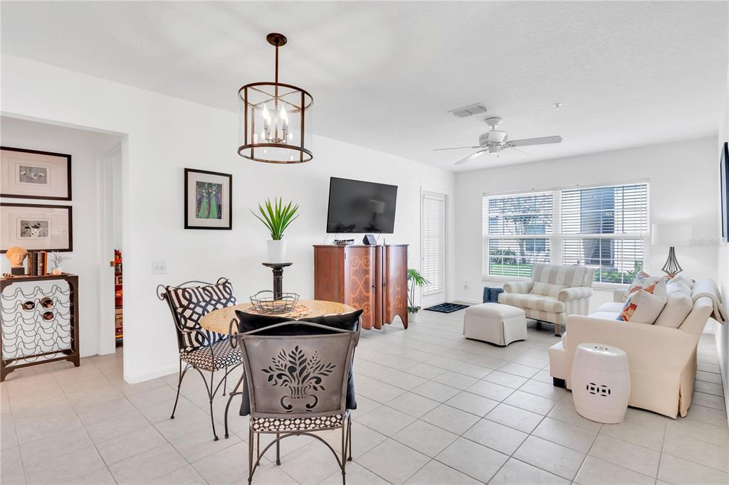 An open-concept living and dining area features tile flooring, a ceiling fan, and neutral decor — 3950 SOUTHPOINTE DRIVE UNIT 409, ORLANDO, FL