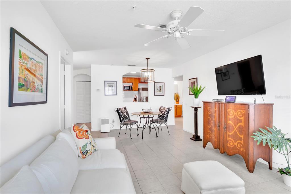 A living room with white walls, tile floors, a ceiling fan, and a dining area — 3950 SOUTHPOINTE DRIVE UNIT 409, ORLANDO, FL