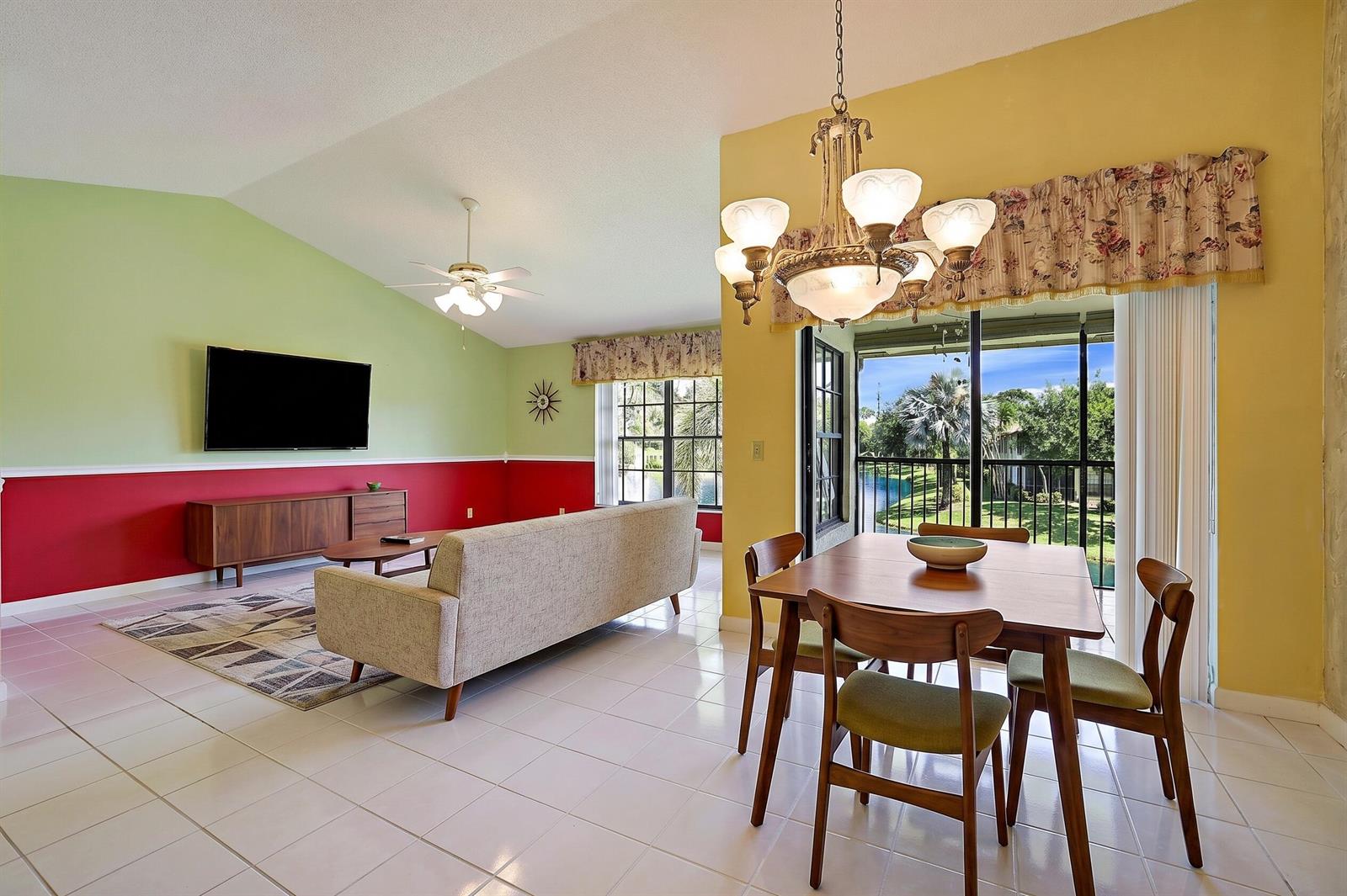A bright living and dining area with tile floors, a chandelier, and a sliding glass door — 3283 Jog Park Drive, FL 33467, FL