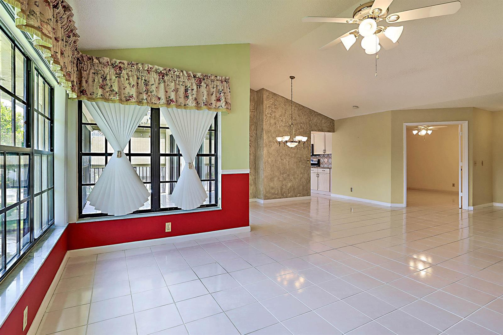 An empty room with white walls, tile flooring, a ceiling fan, and a front door — 3283 Jog Park Drive, FL 33467, FL