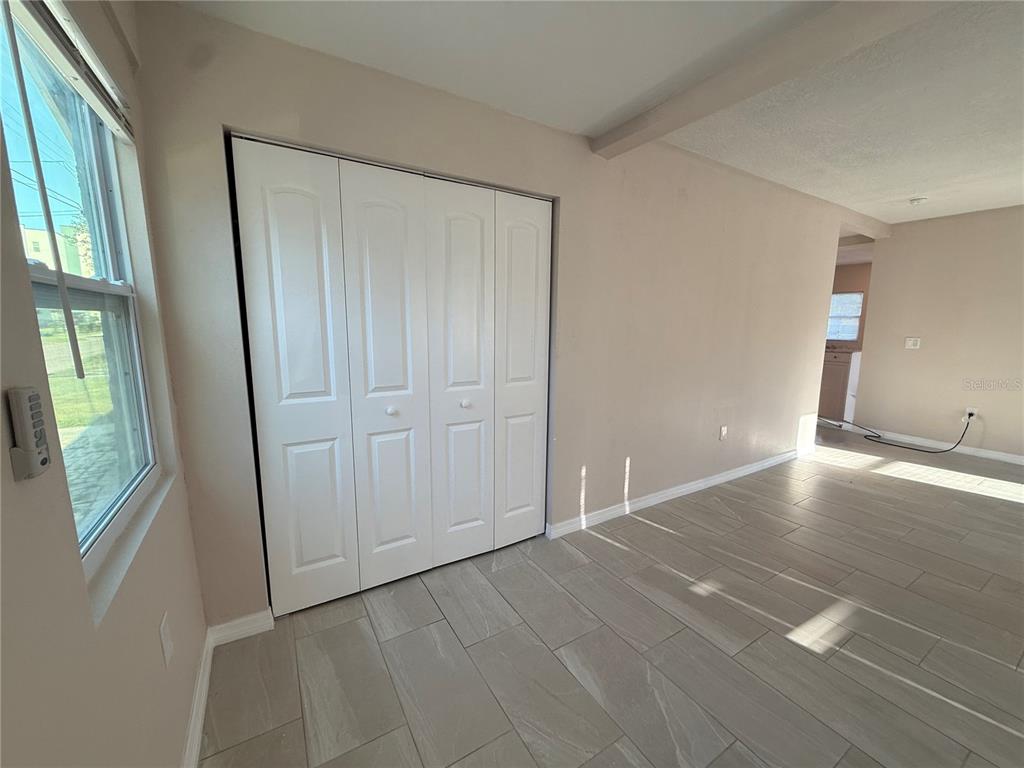 A room with light-colored walls, tile flooring, and a white four-panel folding closet door — 1015 23RD AVENUE W, BRADENTON, FL