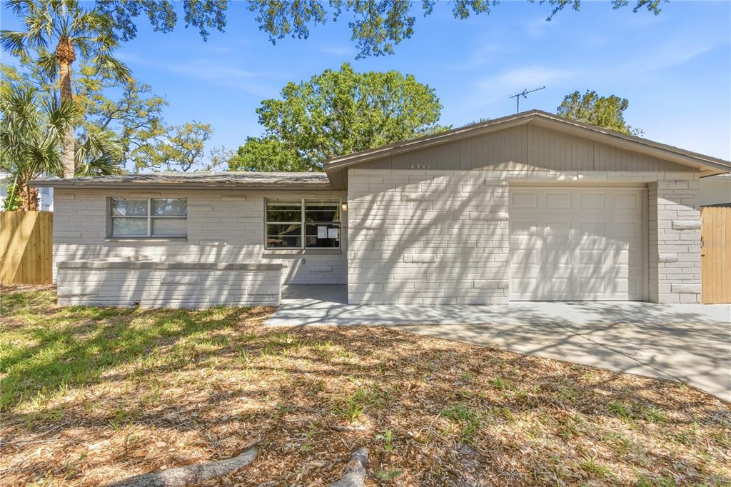 A single-story house with a white brick exterior, a garage, and a front yard — 4941 AMHERST COURT, NEW PORT RICHEY, FL