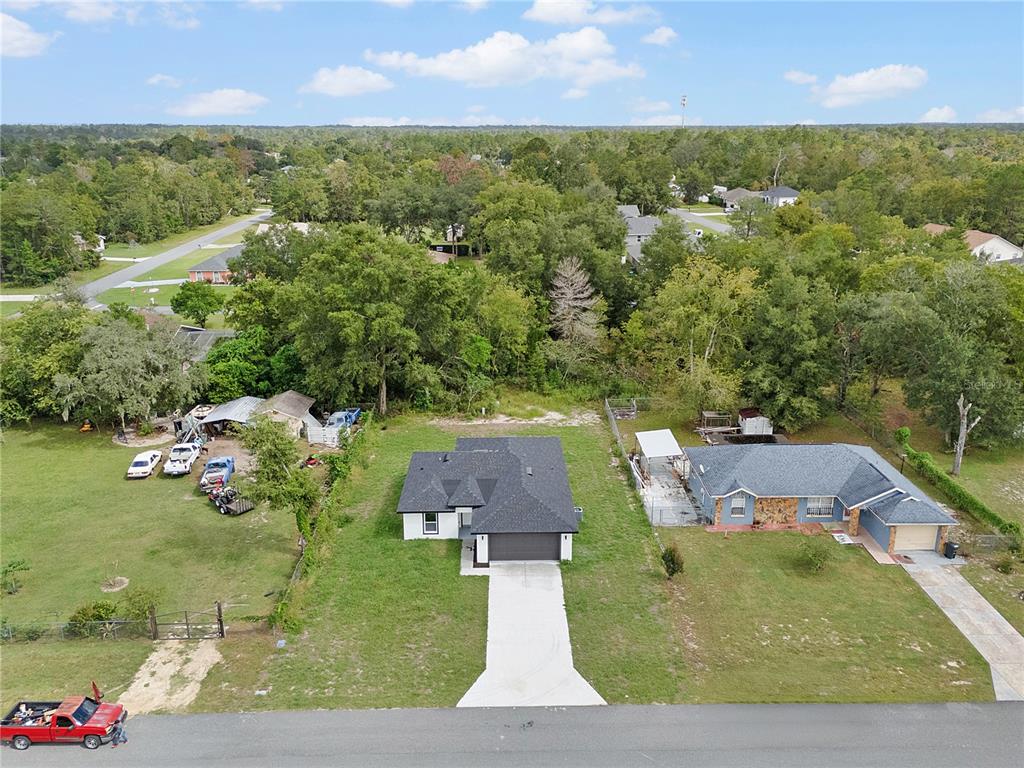 An aerial view shows a single-story house with a concrete driveway and surrounding grassy lots — 13969 SW 45TH TERRACE, OCALA, FL