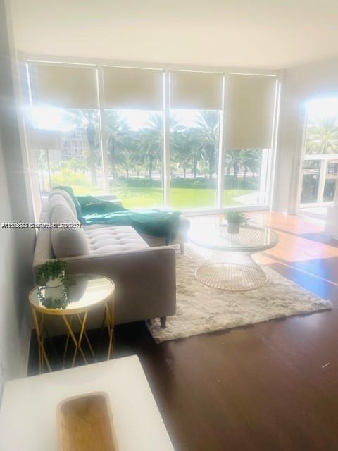 A living room features a beige sofa, a glass coffee table, and large floor-to-ceiling windows — 10275 Collins Ave # 327, Bal Harbour FL 33154, BAL HARBOUR, FL