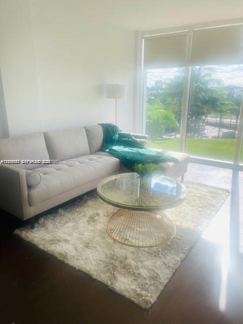 A living room features a beige sectional sofa, a glass coffee table, and large windows — 10275 Collins Ave # 327, Bal Harbour FL 33154, BAL HARBOUR, FL