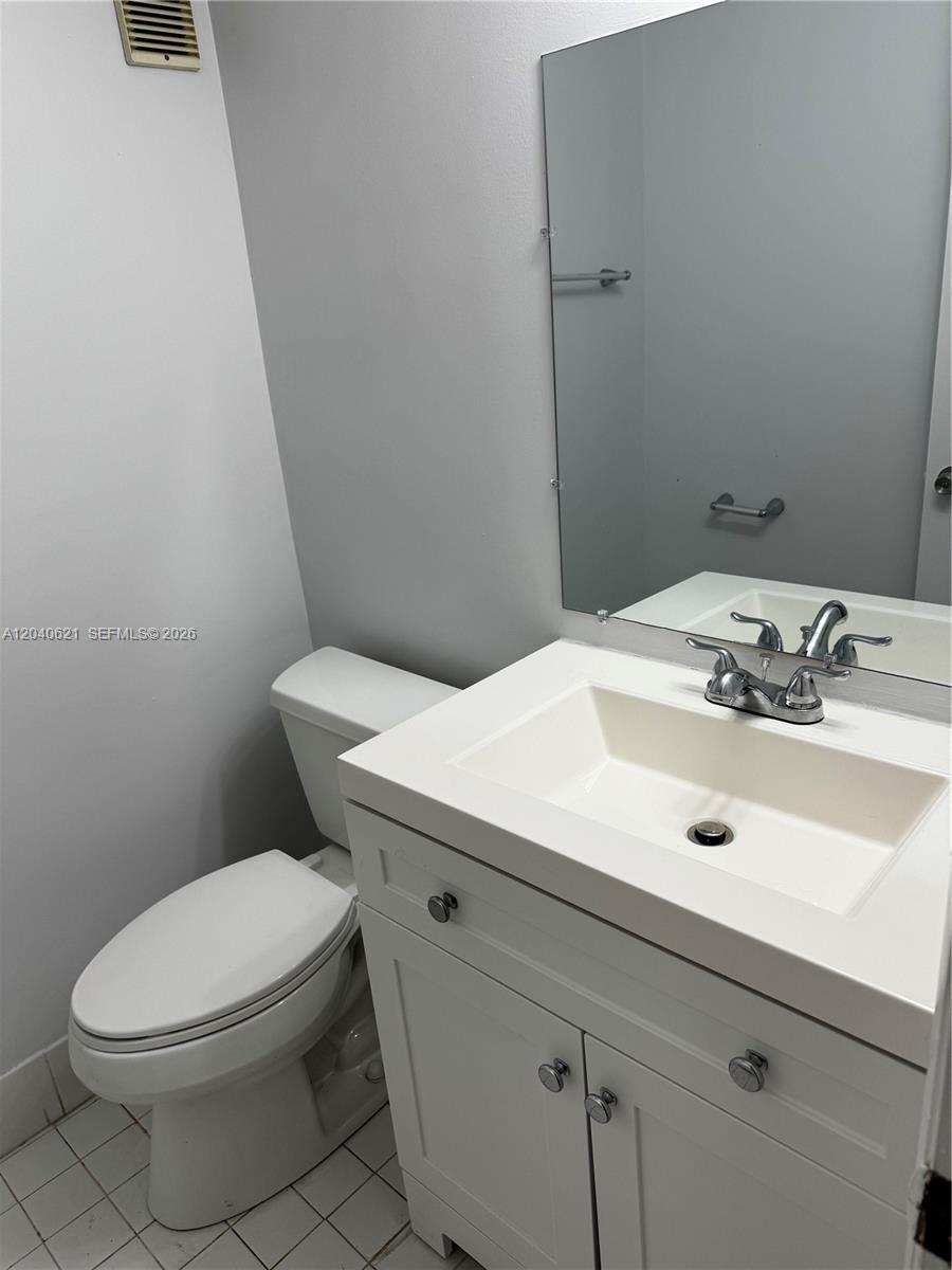A bathroom features a white vanity with a sink, a toilet, and a wall mirror — 13500 NE 3rd Ct # 120, North Miami FL 33161, NORTH MIAMI, FL