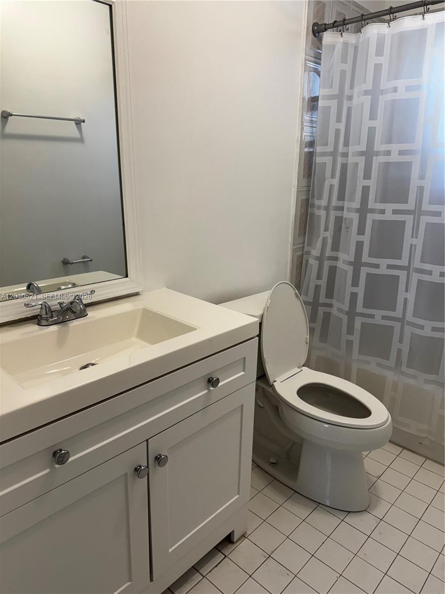 A bathroom features a white vanity with a sink, a toilet, and a shower curtain — 13500 NE 3rd Ct # 120, North Miami FL 33161, NORTH MIAMI, FL