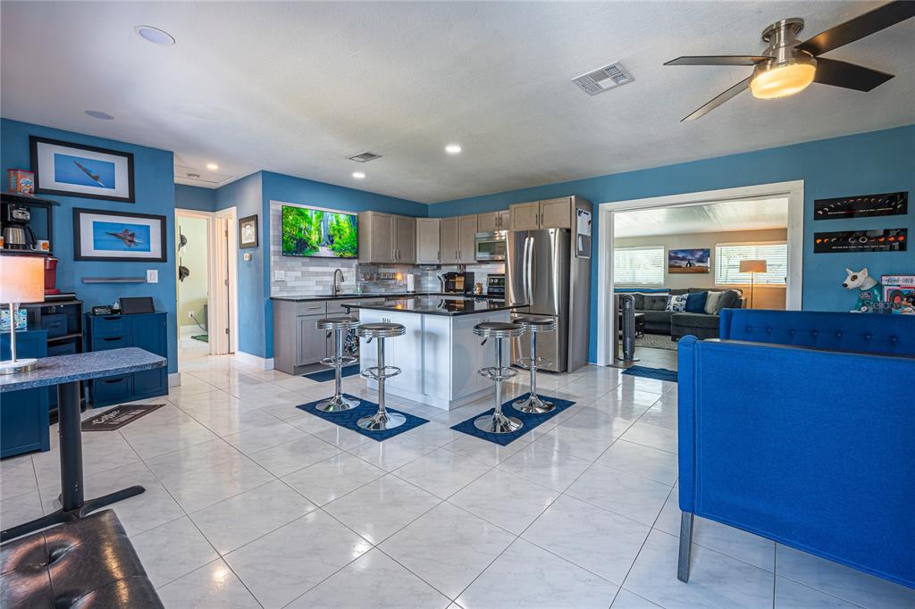 A kitchen with a central island, stainless steel appliances, and blue walls on tile flooring — 5760 3RD AVENUE N, ST PETERSBURG, FL