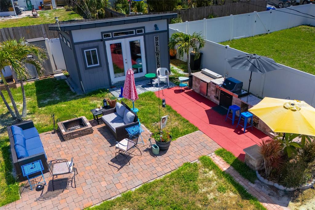 An aerial view shows a backyard patio with a shed, outdoor kitchen, and seating area — 5760 3RD AVENUE N, ST PETERSBURG, FL