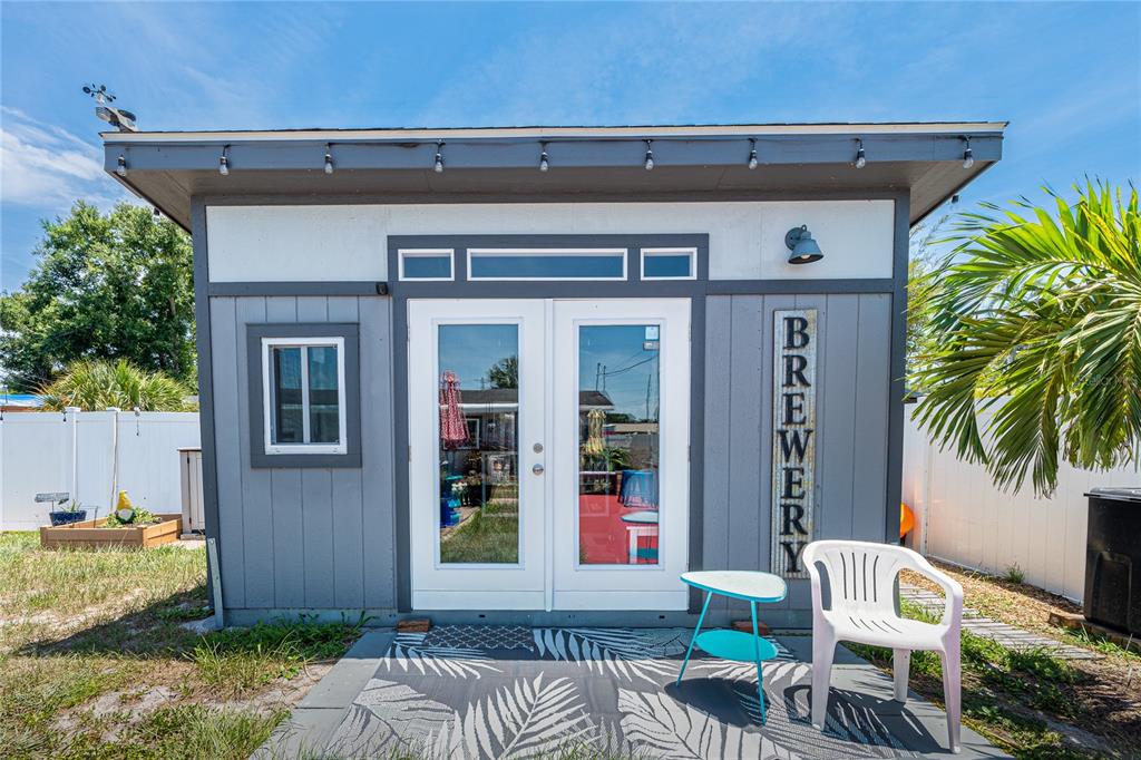 A small, gray-painted backyard shed with double glass doors and a "BREWERY" sign — 5760 3RD AVENUE N, ST PETERSBURG, FL