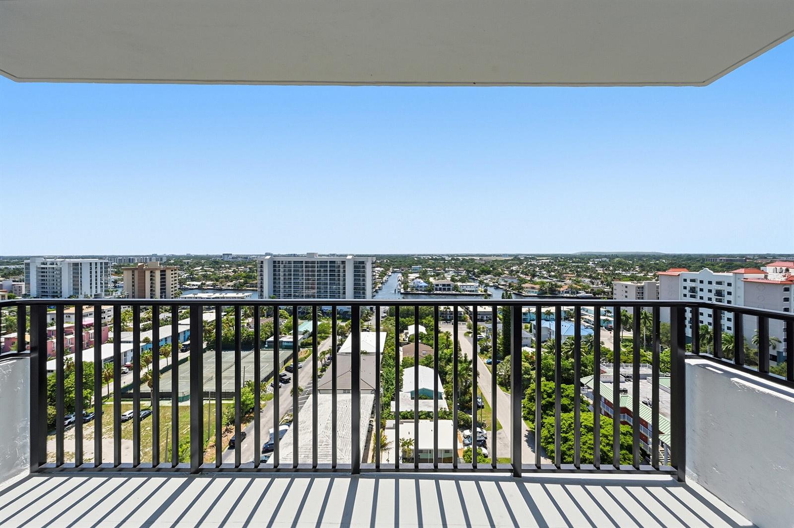 A balcony with a black metal railing overlooks a suburban landscape with buildings and waterways — 531 N Ocean Boulevard # 1601, Pompano Beach FL 33062, POMPANO BEACH, FL
