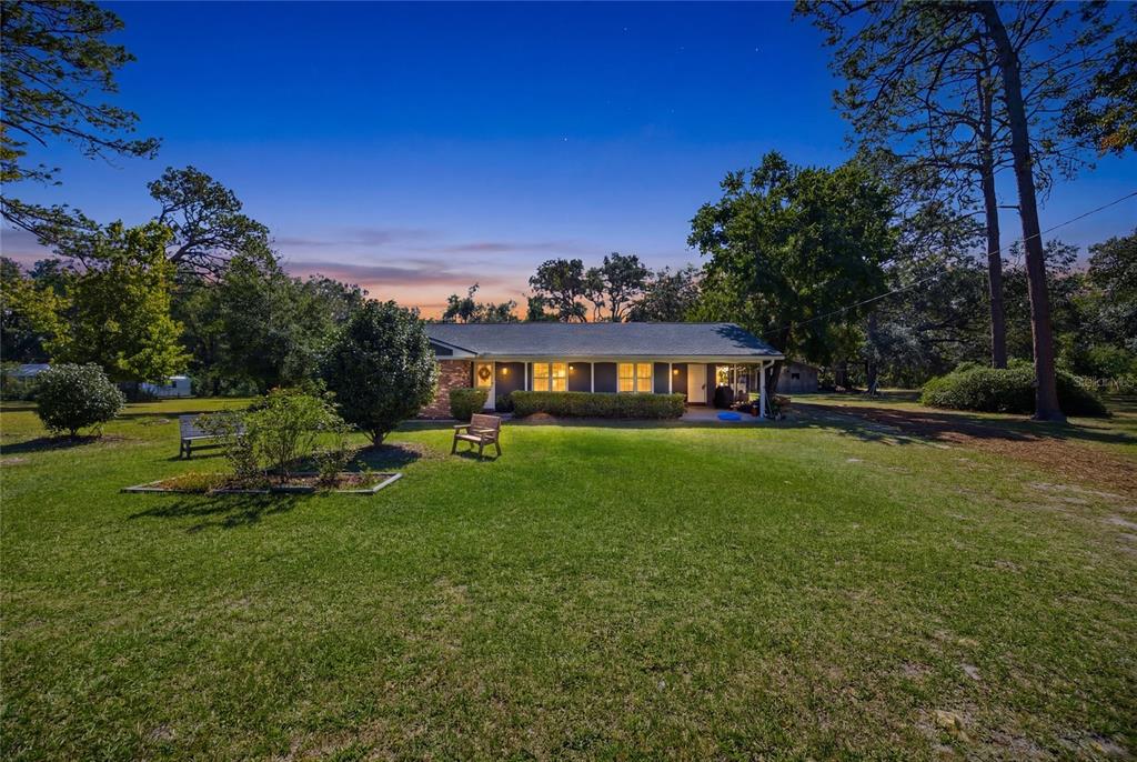 A single-story house with a brick accent wall sits on a large, grassy lawn — 1638 SW KING STREET, LAKE CITY, FL