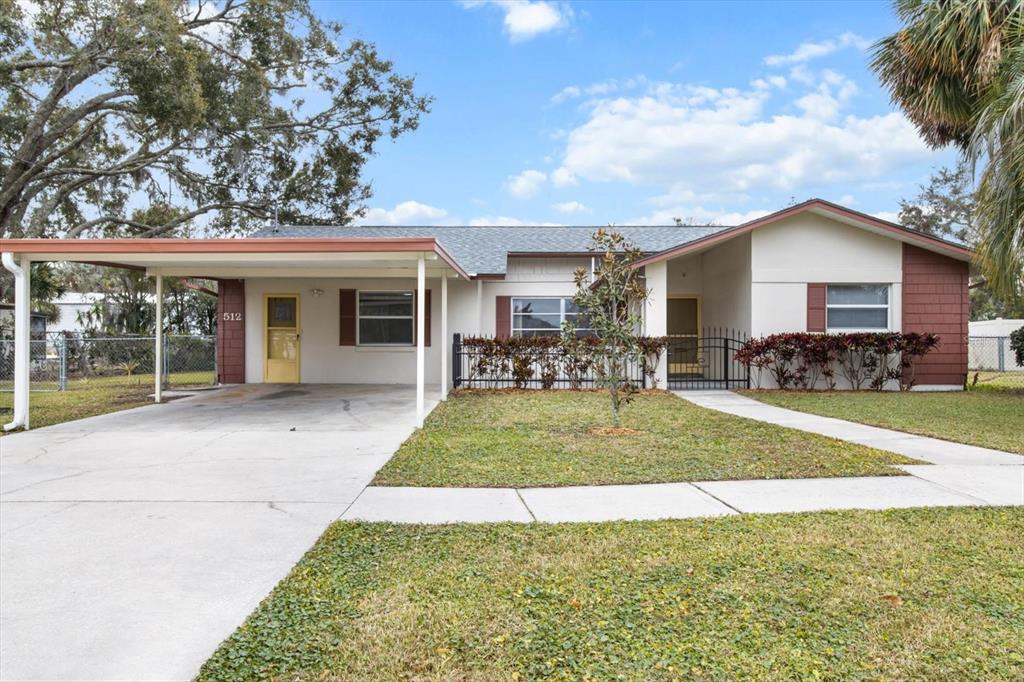 A single-story house with a carport, a front lawn, and a walkway leading to the entrance — 512 PARADISE POINT, CRYSTAL RIVER, FL