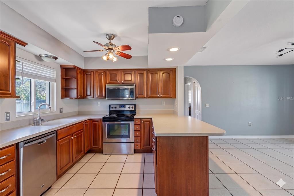 A bright living room features light gray walls, large windows, and beige tiled flooring — 605 S FLORIDA AVENUE, TARPON SPRINGS, FL