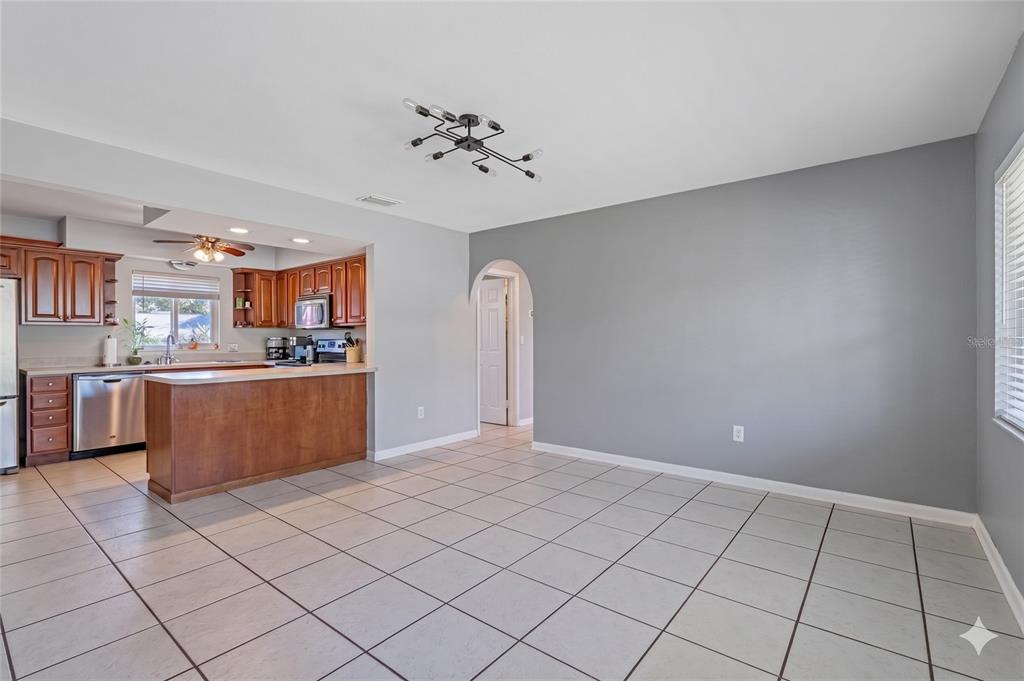 A kitchen with wood cabinets, stainless steel appliances, and a peninsula counter on tile flooring — 605 S FLORIDA AVENUE, TARPON SPRINGS, FL