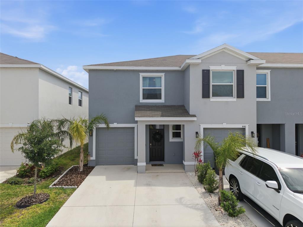 A two-story gray townhouse with a concrete driveway, a front porch, and a white SUV — 444 MANGROVE SHADE CIRCLE, APOLLO BEACH, FL