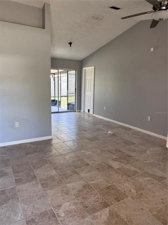 An interior view of a room with gray walls, tile flooring, and a sliding glass door — 4764 MALLARD DRIVE, ST CLOUD, FL