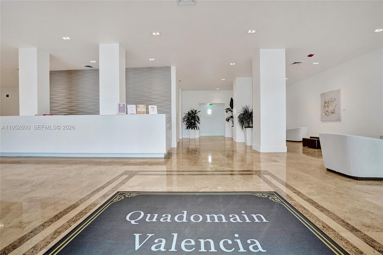 A modern lobby features a white reception desk, tiled floors, and a branded entrance mat — 2201 S Ocean Dr # 608, Hollywood FL 33019, HOLLYWOOD, FL