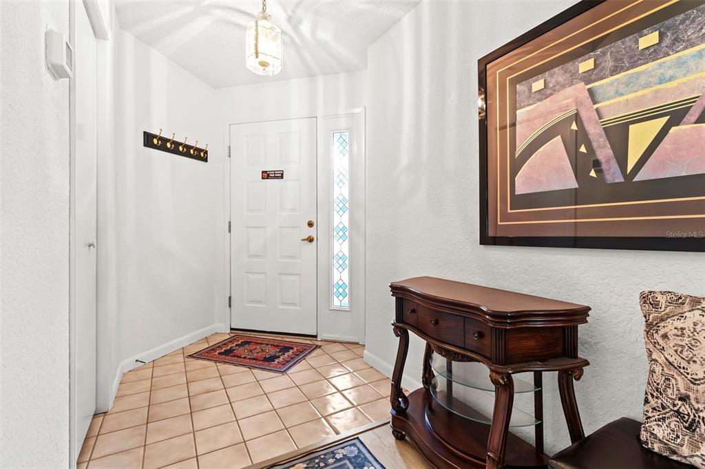 An entryway features tiled flooring, a white front door with a sidelight, and a console table — 9288 NEW ORLEANS DRIVE, WEEKI WACHEE, FL